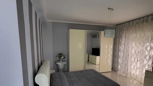 A bedroom with a bed, a bedside table, a mirror, and a wardrobe. - Apartment 3 min from the Museum (Napoli)