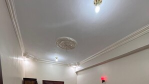 A hotel room with two beds, a wooden wardrobe, a door, and a ceiling light. - Al-Manara Hostel Siwa Oasis (Siwa)