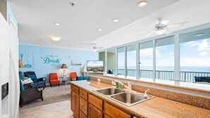A kitchen with a large window, a ceiling fan, and a view of the ocean. - Welcome to our Beach Dream View, The Sunrise and Sunset are breath taking (Gulf Shores)