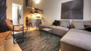 A modern living room with a sofa, a chair, a coffee table, and a dining area with a table and chairs. - Luxury Living in the Heart of the City (Cagliari)
