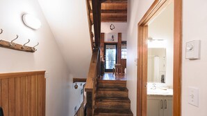 Una escalera de madera que conduce a un baño con un lavabo y armarios.