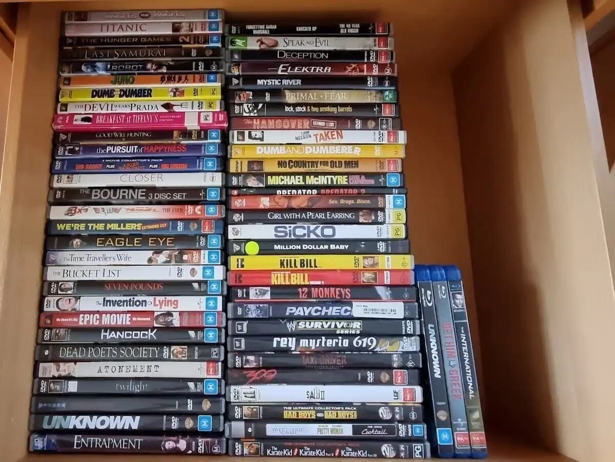 A collection of DVDs organized in a wooden cabinet.