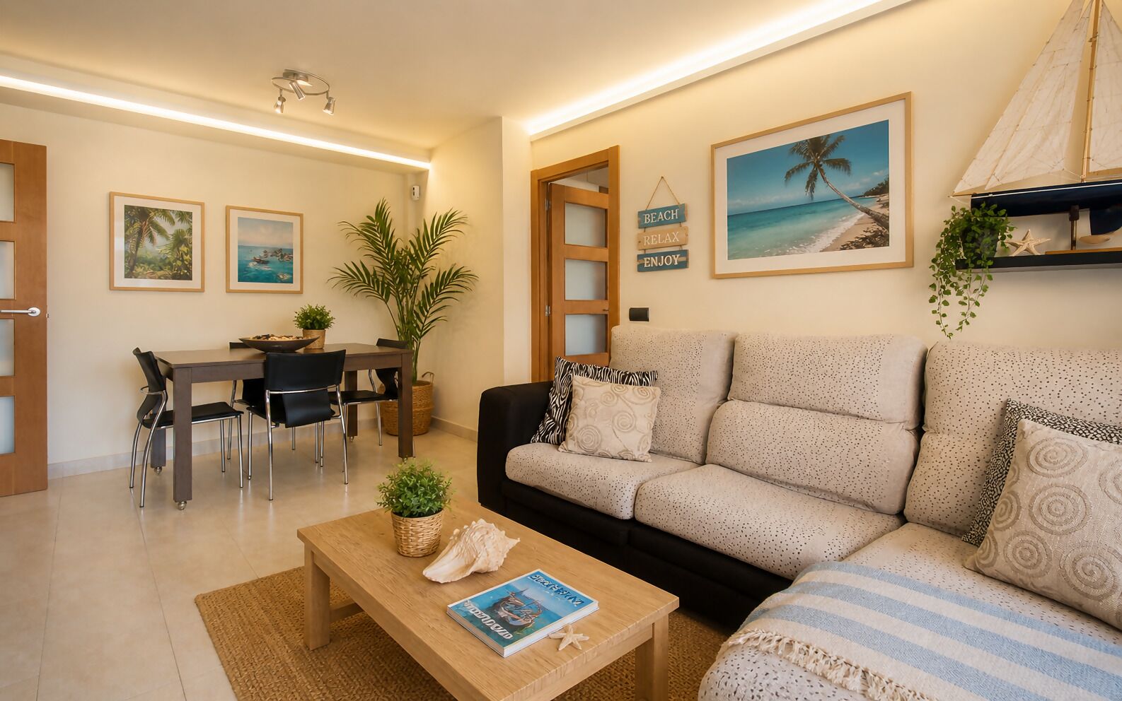 Uma sala de estar moderna com sofá, mesa de centro, mesa de jantar, cadeiras e quadros na parede.