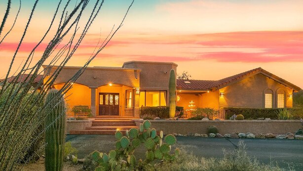 A two-story house with a patio, a cactus garden, and a sunset sky. - Mountain Home Pool VIEWS Garage FUN Backyard Spacious Private Close to UofA
 (Tucson)