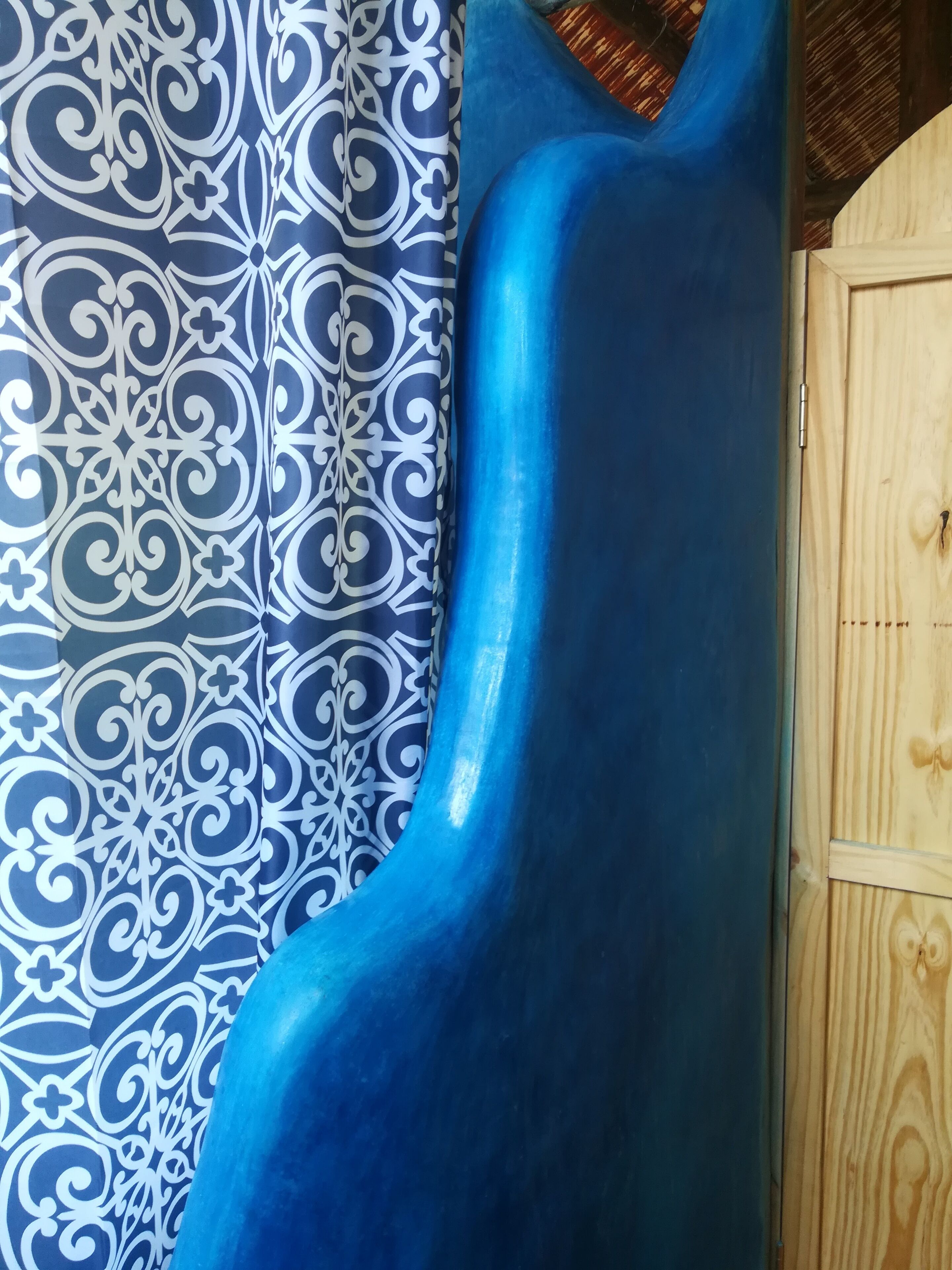 Un tobogán azul con un diseño decorativo en la pared de fondo.