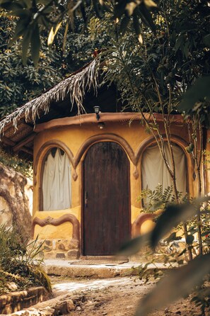 A rustic hut with a thatched roof, a wooden door, and a stone pathway leading to it. - Sol de minca (Santa Marta)