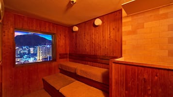 A wooden room with a window overlooking a cityscape at night.