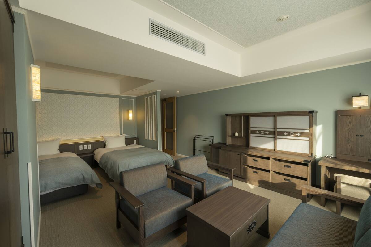 Ein Hotelzimmer mit zwei Betten, einer Couch, einem Schreibtisch und einem Schrank.
