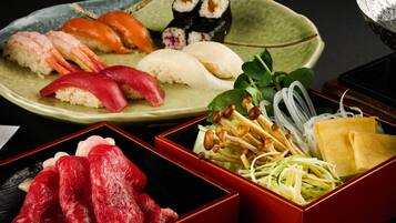 A variety of sushi and sashimi on a plate, including nigiri and maki rolls.