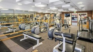 A gym with exercise equipment, a mirrored wall, and a television. - Park City condo for Pre Sundance (Park City)