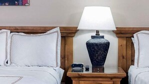 A hotel room with two beds, a nightstand with a lamp, and a small table. - Park City condo for Pre Sundance (Park City)