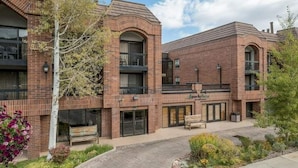 A brick building with a central courtyard, benches, and a small tree. - Park City condo for Pre Sundance (Park City)