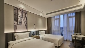 A hotel room with two beds, a desk, a chair, and a large window with curtains. - Qing Dao bu ke bu zhu hotel (Qingdao)