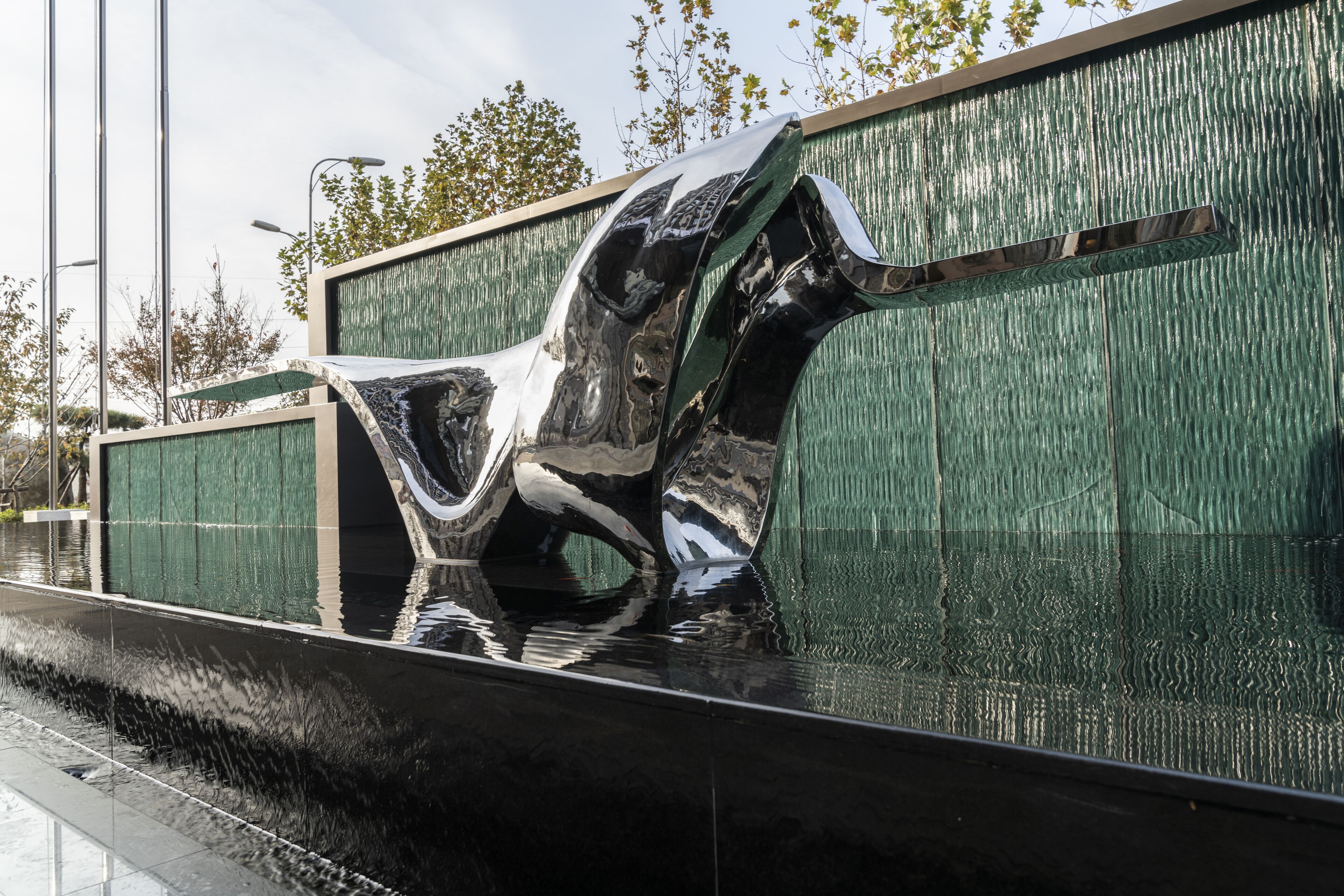 A modern sculpture with a reflective surface in a public space.