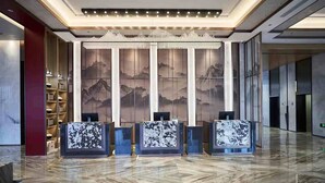 A spacious lobby with a marble floor, a reception desk, and a large wall mural. - Qing Dao bu ke bu zhu hotel (Qingdao)
