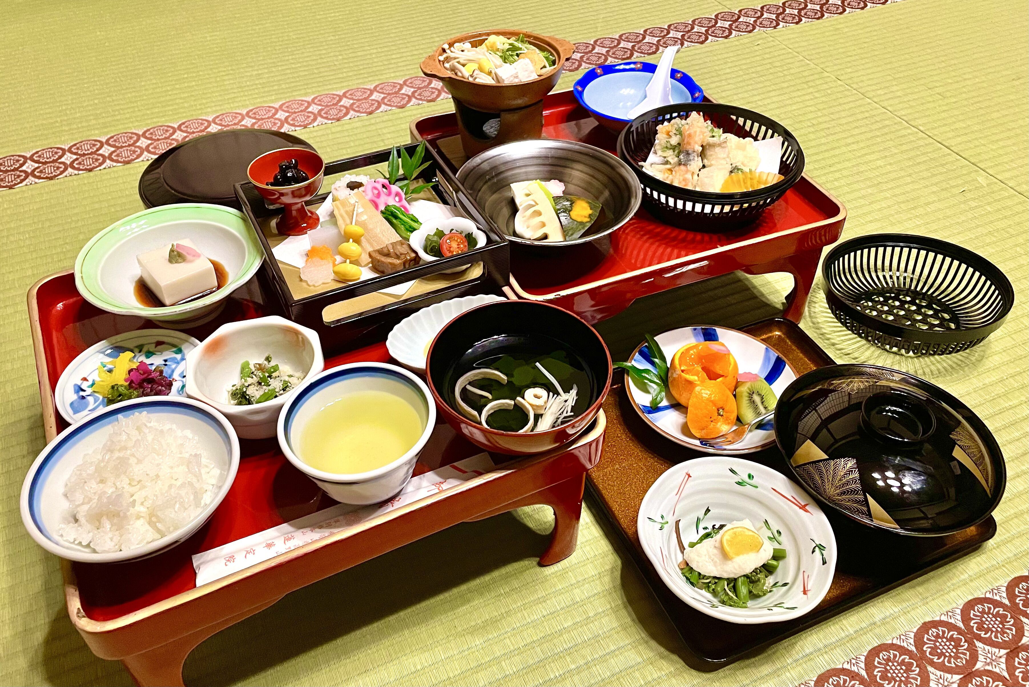 Un repas japonais traditionnel, composé de différents plats et présenté avec les ustensiles nécessaires sur un plateau.