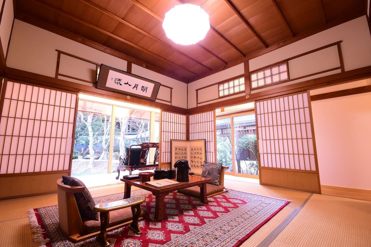 A traditional Japanese room with tatami flooring, a low wooden table, and a sliding door.