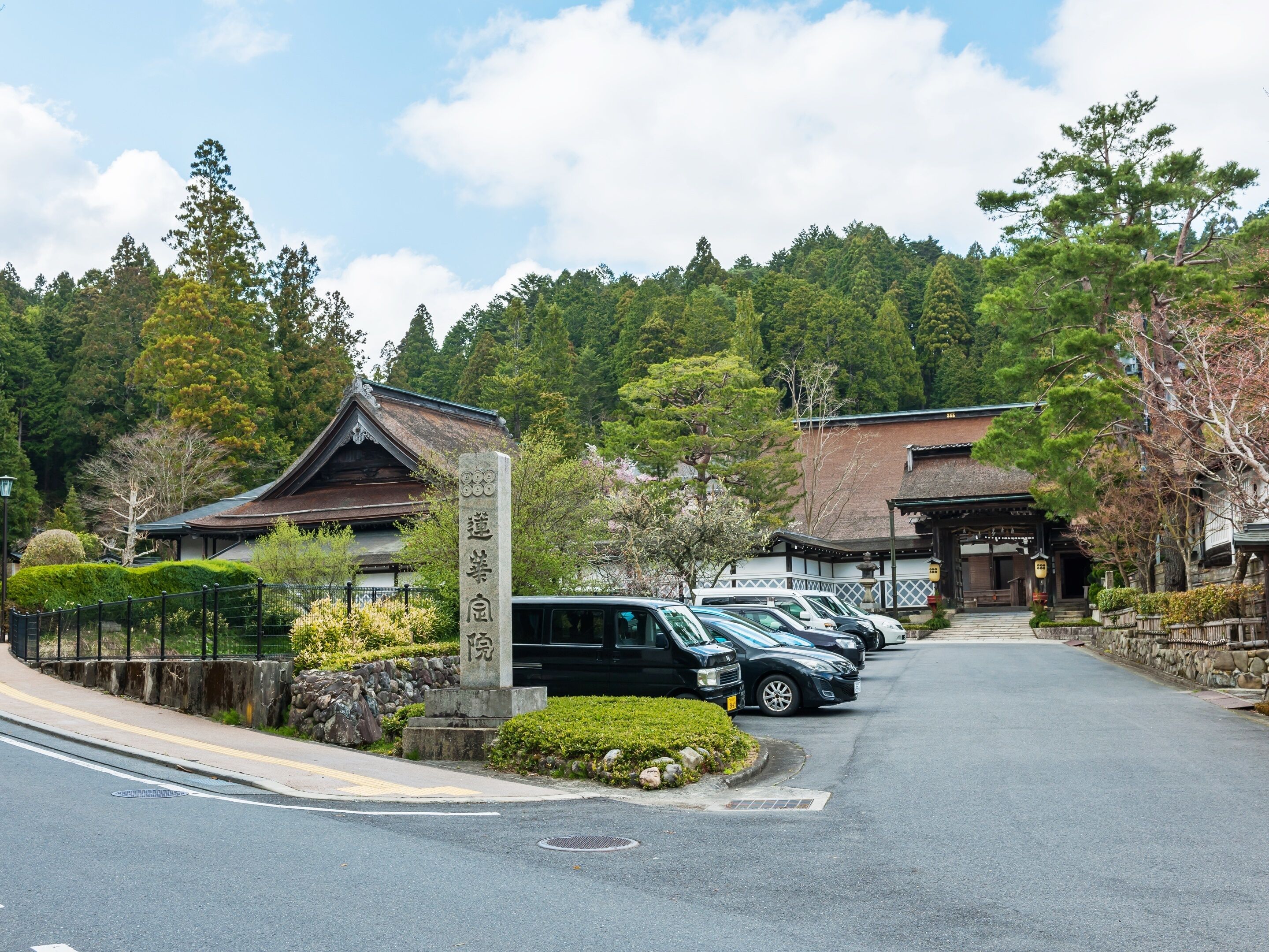 A traditional Japanese building with a parking area in front.