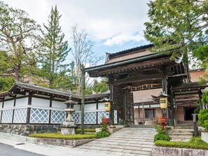 A traditional Japanese building with a wooden structure, stone steps, and a stone lantern.