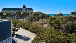 A beachfront property with a large stone building, a paved walkway, and dense shrubbery. - EXQUISITE BEACH HAVEN! PERFECT ROMANTIC GETAWAY! DOG FRIENDLY! (Destin)