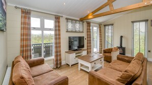 A spacious living room with a television, sofa, and a fireplace.