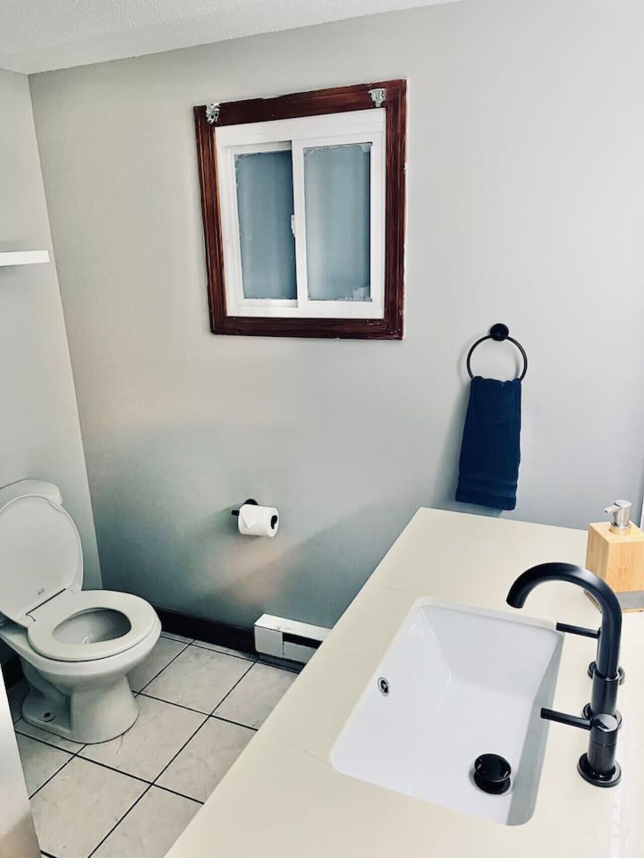 Ein Badezimmer mit Toilette, Waschbecken und Fenster.