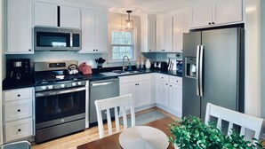 A modern kitchen with white cabinets, stainless steel appliances, and a central island with seating.