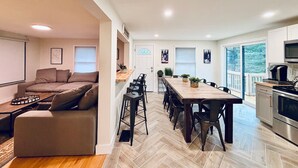 Una cocina moderna con comedor, sofá y televisor.