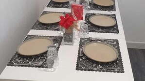 Een eettafel gedekt met borden, glazen en een middelpunt.