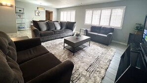 A living room with a sectional sofa, a coffee table, and a TV.
