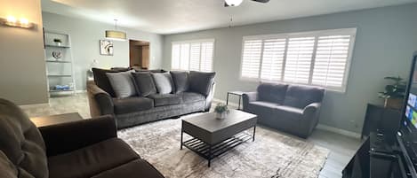 A living room with a sectional sofa, a coffee table, and a TV.