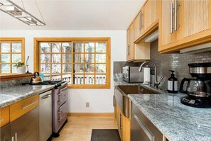Enjoy cooking in this kitchen with a stove, microwave, and coffee maker, and take in the view from the large windows.