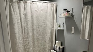 Un baño con inodoro, lavamanos y cortina de ducha.