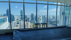 A room with a large window offering a city view, a bed, and two stools. - Best Location, 2 bed, 2baths, High Speed Internet (Panamá)