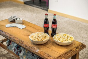 A wooden table with two bowls of popcorn, two Coca-Cola bottles, and a box of tissues. - LOG CABIN w/Mtn View, Hot Tub, & Fireplace! (Divide)