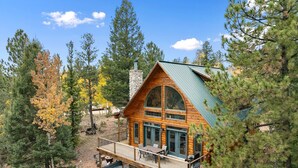 A log cabin with a balcony, a hot tub, and a stone chimney. - LOG CABIN w/Mtn View, Hot Tub, & Fireplace! (Divide)