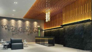 A modern lobby with a reception desk, seating area, and decorative wall art.