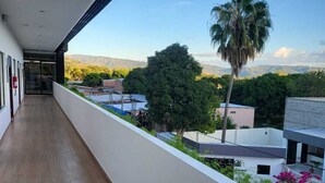 A balcony with a view of mountains and palm trees.
