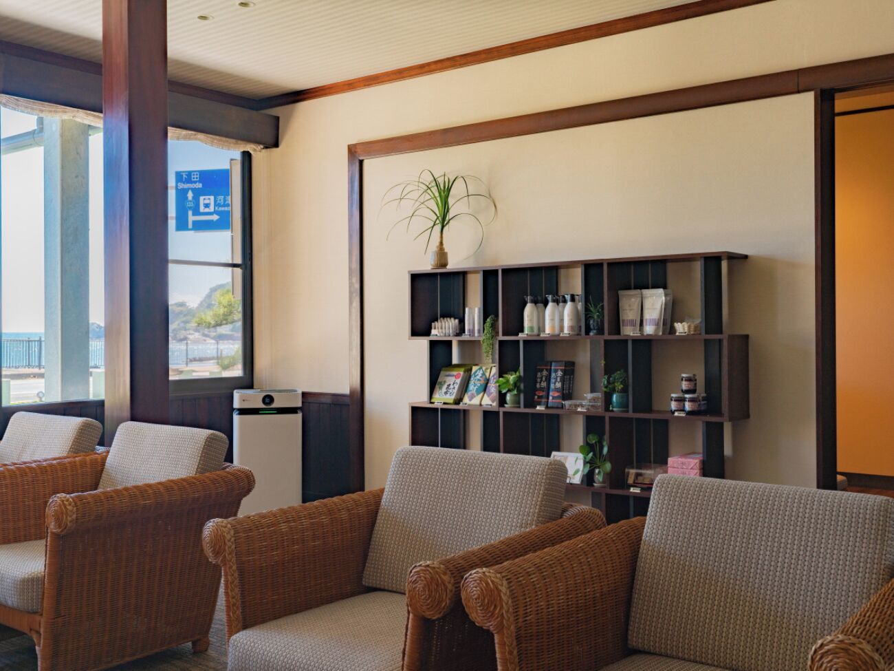 A seating area with wicker chairs and a bookshelf.