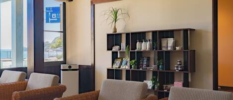 A seating area with wicker chairs and a bookshelf.