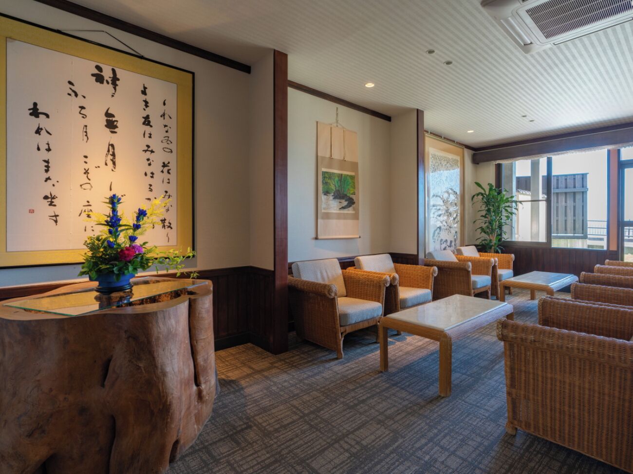 Un intérieur de style japonais traditionnel, avec un sol recouvert de tatamis, de basses tables en bois et des sièges rembourrés.