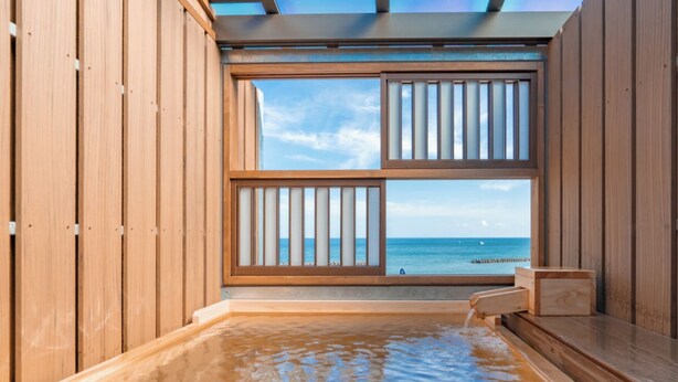 Una bañera de hidromasaje de madera con vista al océano.
