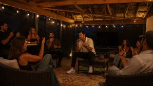 An outdoor seating area with wicker furniture, a patterned rug, and string lights. - Spa Weekend Near WinStar Spa or Golf Included (Thackerville)