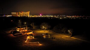 A nighttime view of a hotel with multiple buildings, a parking area, and a well-lit entrance. - Spa Weekend Near WinStar Spa or Golf Included (Thackerville)