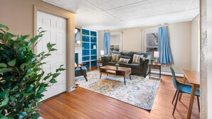 A living room with a sofa, coffee table, and a dining area with a table and chairs. - King Bed Private Parking  Fast Internet (Poughkeepsie)