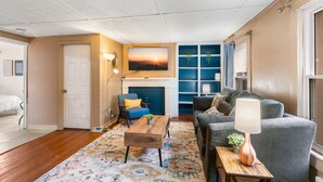 A living room with a fireplace, a sofa, a coffee table, and a lamp. - King Bed Private Parking  Fast Internet (Poughkeepsie)