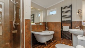 Une salle de bain moderne avec une douche à parois de verre, une baignoire sur pieds, des toilettes et un lavabo.