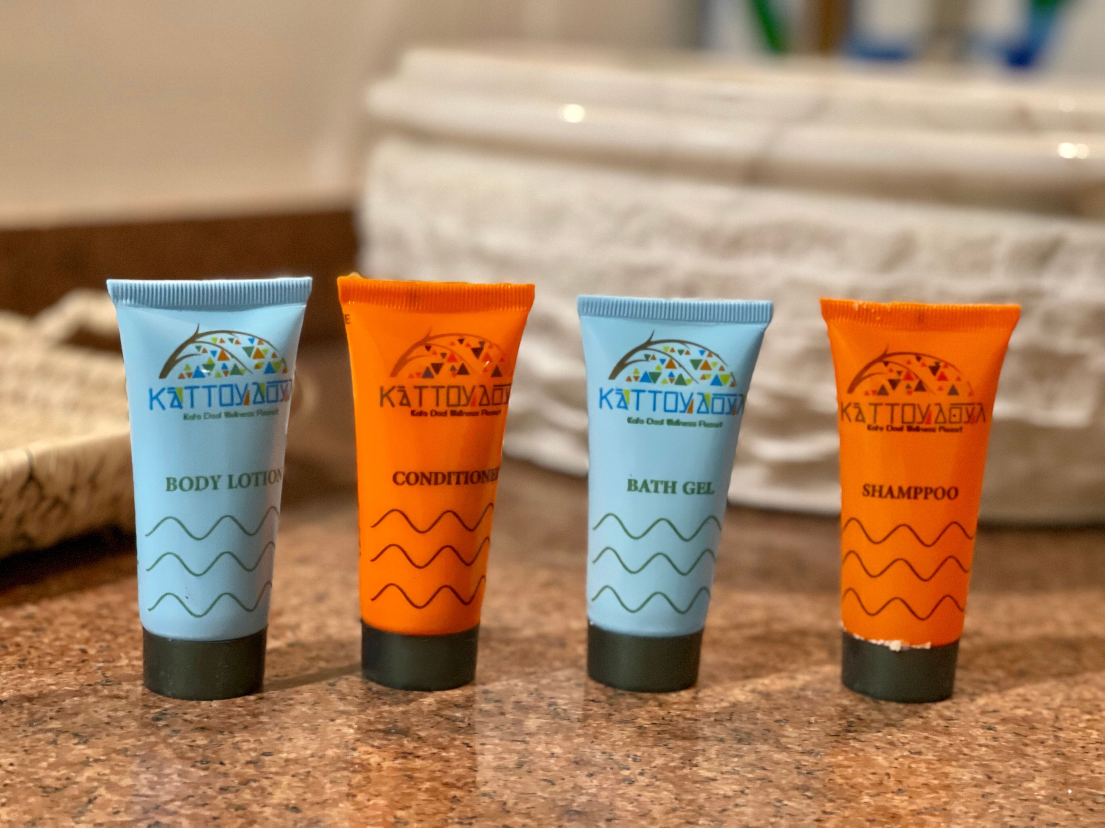 Quatro tubos de produtos de cuidados para o corpo Kattoyaya sobre um balcão.