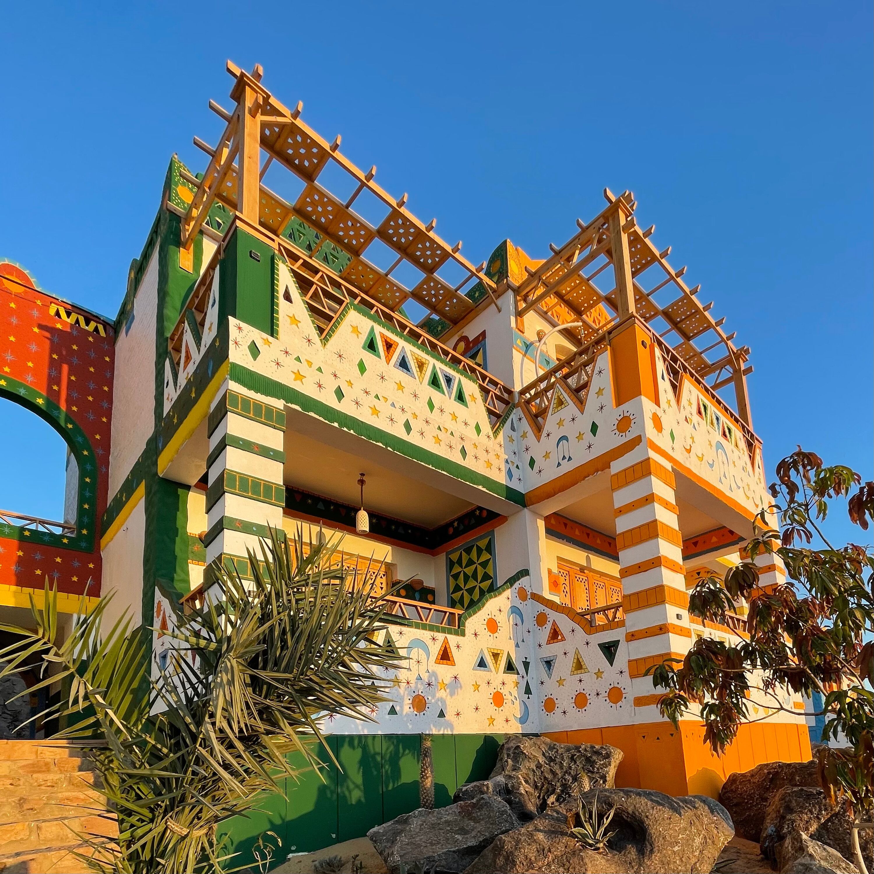 A colorful building with a unique architectural design, featuring multiple balconies and a mix of geometric patterns.