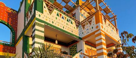 A colorful building with a unique architectural design, featuring multiple balconies and a mix of geometric patterns.